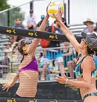 Image 24Two opposing players simultaneously contact the ball above the net with open hands, known as a "joust". The receiving team is entitled to another three contacts. (from Beach volleyball)