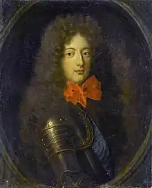 A young man in armor with a big red bow on his neck.
