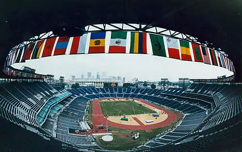 Stadium from a perspective high in the seats, with a row of national flags at the top of the stands