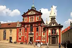 The convent building, attached to the left of the red-colored Basilica of St. George