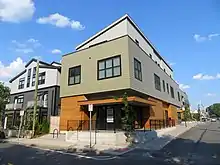 A modern three-story residential building in an urban area