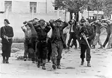 Captured men, with hands behind their heads