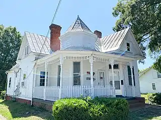 Danville North two story 1895 frame home built with other identical homes. It has a two-story full-width porch and dual entrances.