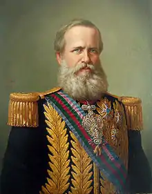 A half-length photograph showing an older man with a full beard who is dressed in a dark coat, white shirt and dark vest