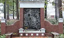 The memorial the end of a pathway featuring a brick monument with a bronze centerpiece