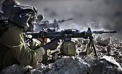IDF infantry soldier fires a Negev light machine gun during training