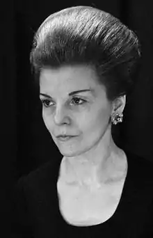 A photograph of a white woman in front of a black background