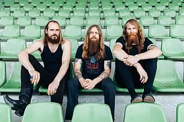 Image 6KadavarPhotograph: Henry W. LaurischKadavar are a rock band from Berlin, Germany, founded in 2010. Their retro sound, incorporating psychedelic rock and stoner rock, has been compared to bands of the 1970s hard rock/heavy metal era. Kadavar currently consists of three members: guitarist and lead vocalist Christoph "Lupus" Lindemann, drummer Christoph "Tiger" Bartelt, and bassist Simon "Dragon" Bouteloup.