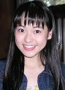 A close-up photo of Yamamoto smiling while wearing a denim jacket