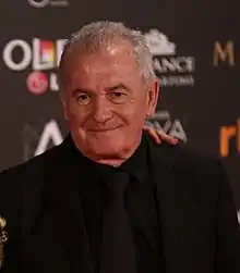 A man is wearing black and is facing someone on the left