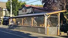 Photograph of the exterior of a building and covered outdoor seating