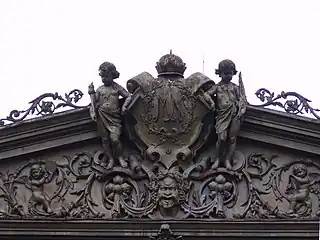 Pura Mangkunagaran coat of arms flanked by European style cherubims and a Dhwarapala