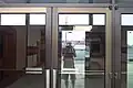 Looking through the front entrance windows of the vacant St. Charles Mall after closure. (First set of doors)