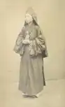 A woman of the Nguyễn dynasty wearing a Áo tràng vạt and a Quan Âm hat